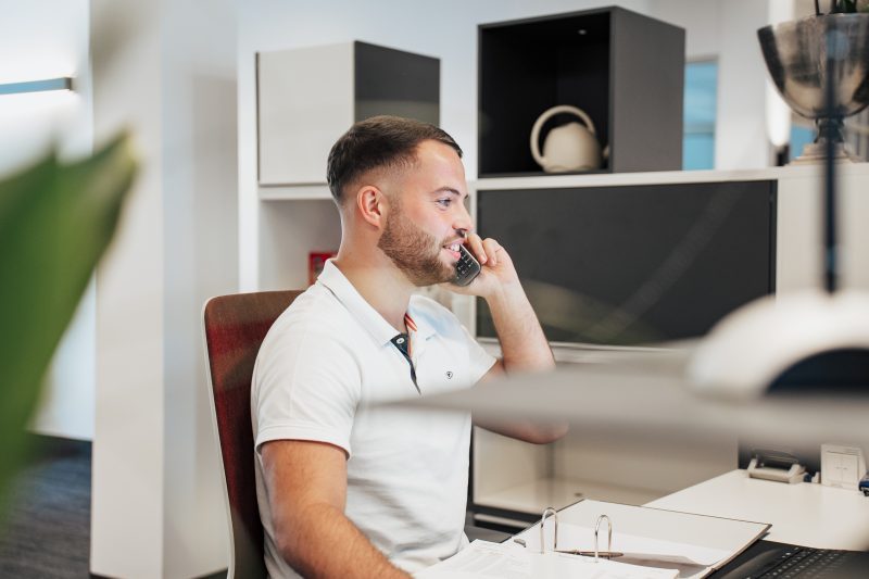 Junger Mann am Empfang mit Telefon